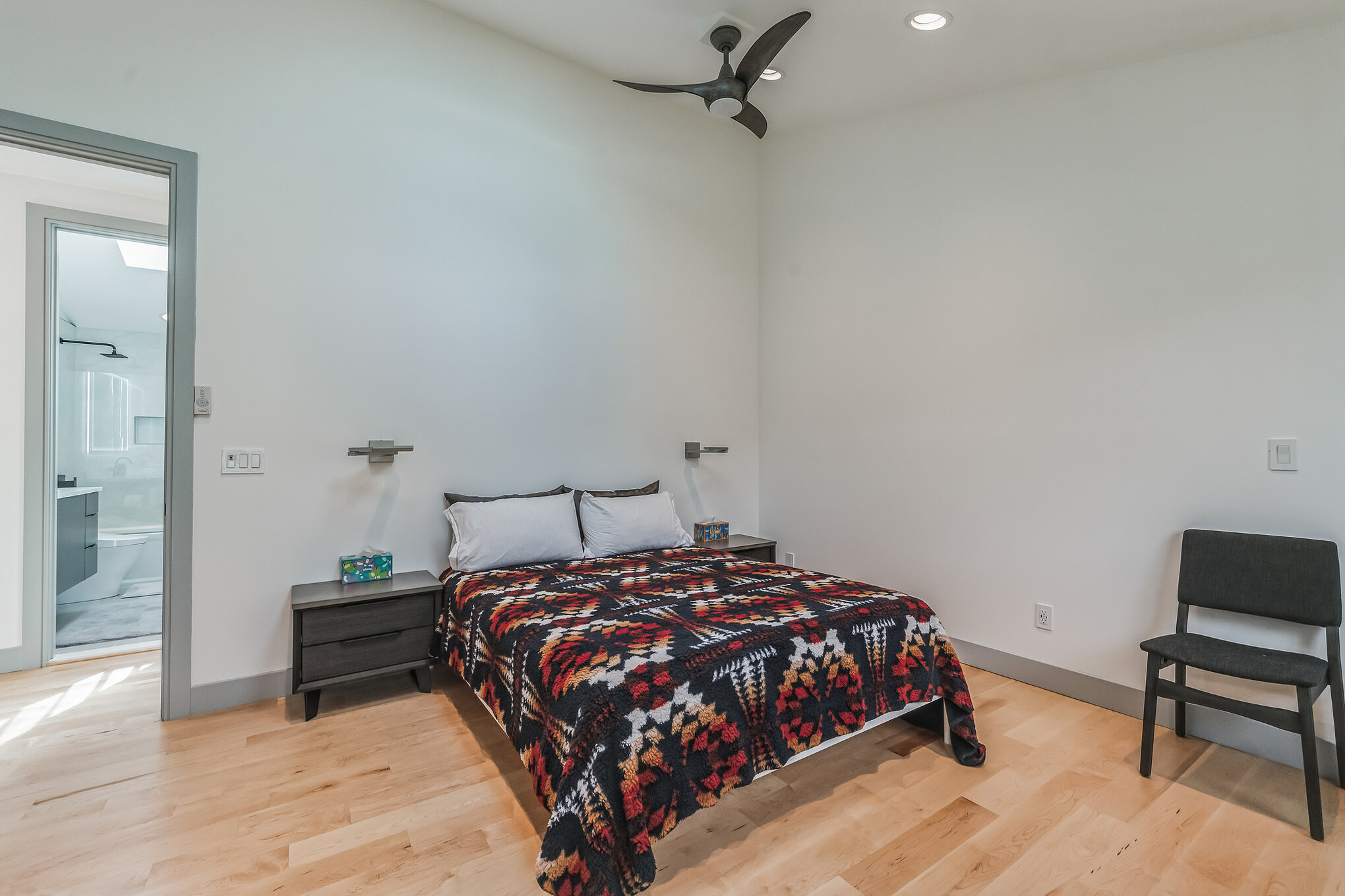 Modern garage loft bathroom with glass shower, dark vanity, and towel warmer