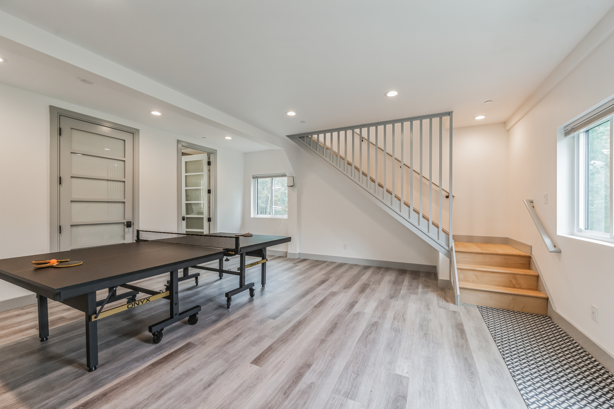 Modern black two-car garage with wood accents and side entry door