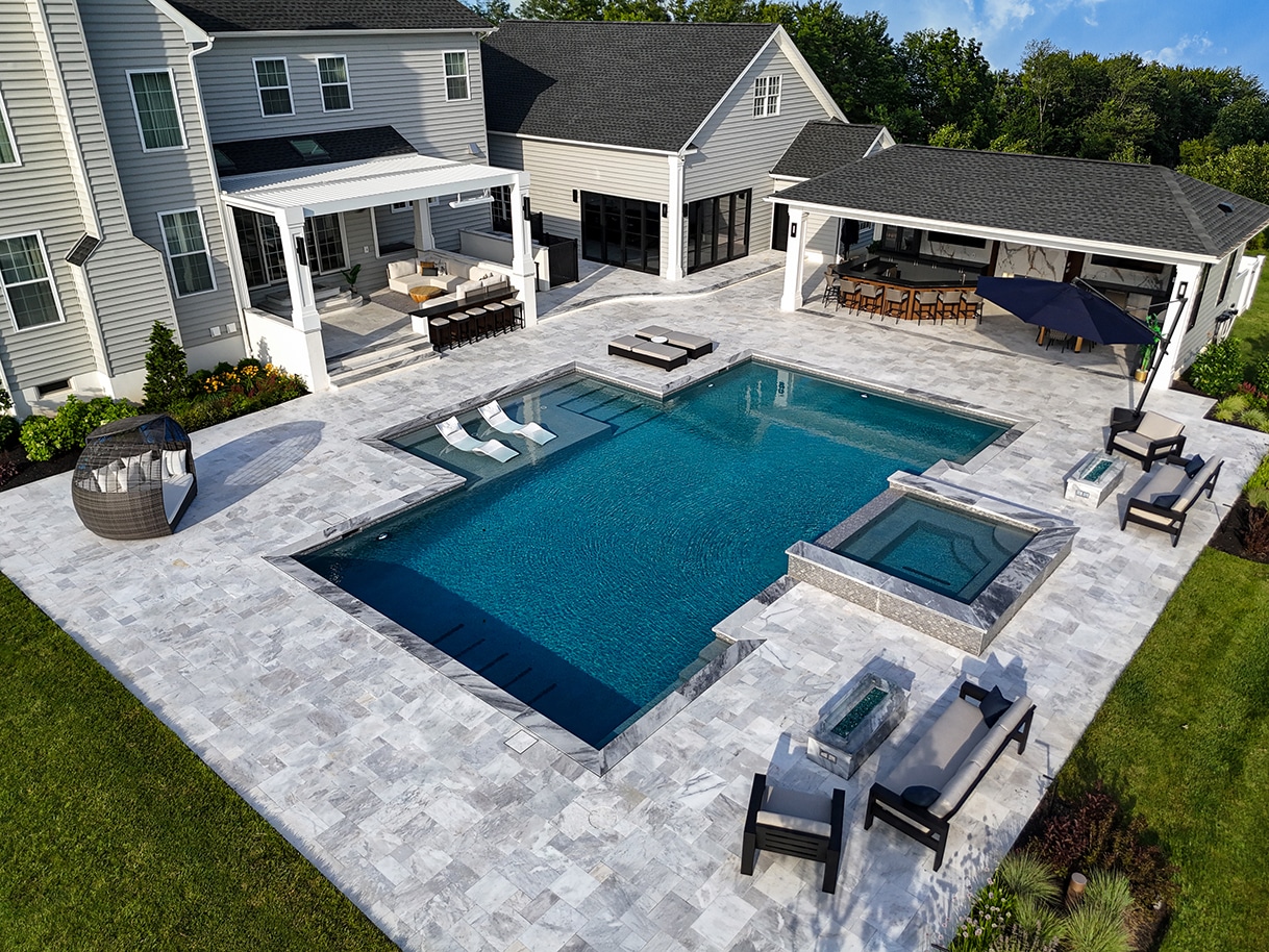 Home gym with sliding glass doors opening to a pool and outdoor pergola at sunset