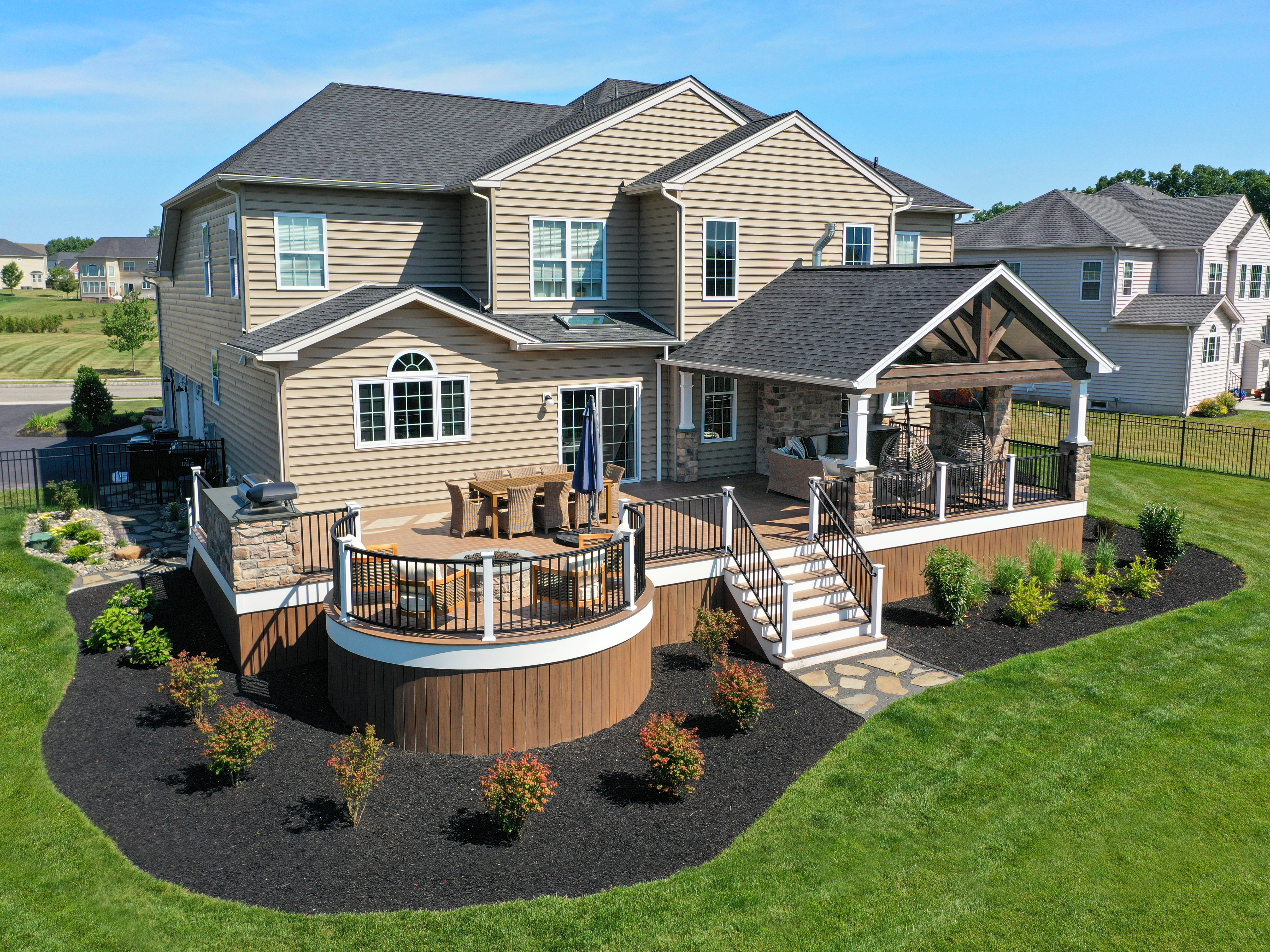 Covered patio with fireplace, TV, sectional seating, and outdoor heaters