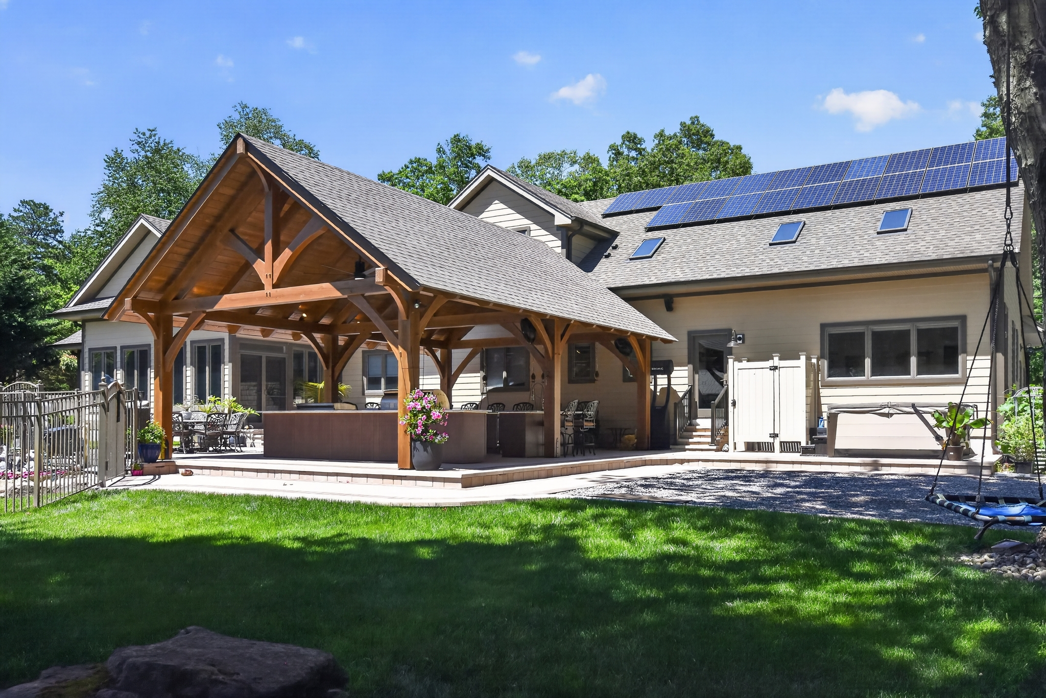 Alpine-style pavilion with wood posts and metal roof over a stone patio